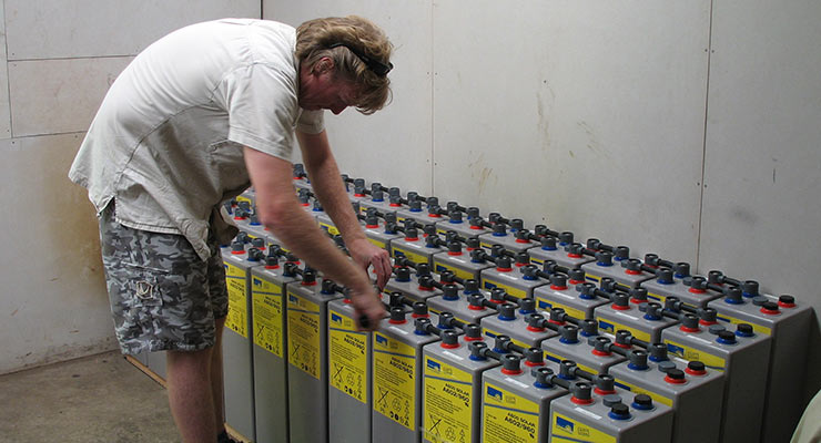 installer working on off-grid solar batteries