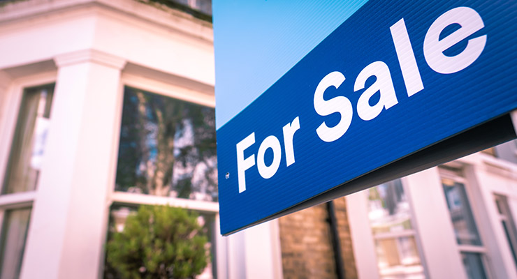for sale sign in front of house