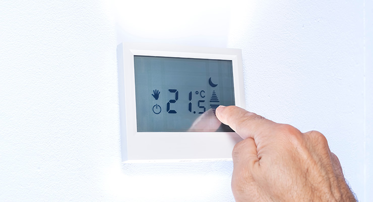 hand using air conditioner thermostat