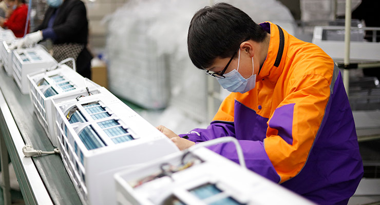 Workers assemble air conditioners