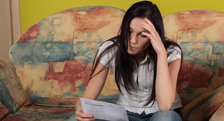 woman looking at electricity bill with sadness