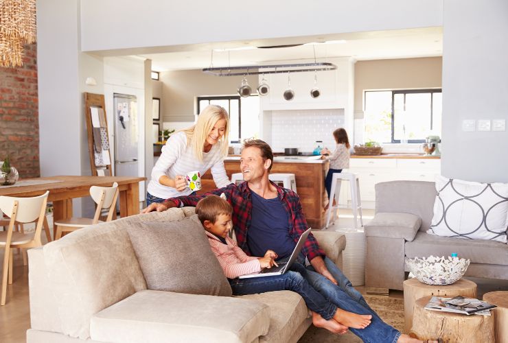 family sitting on couch and talking with working energy