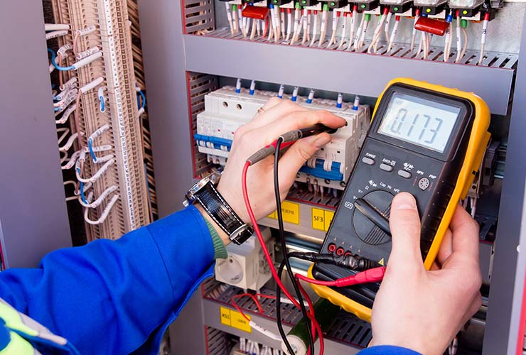 multimeter is in hands of engineer in electrical cabinet