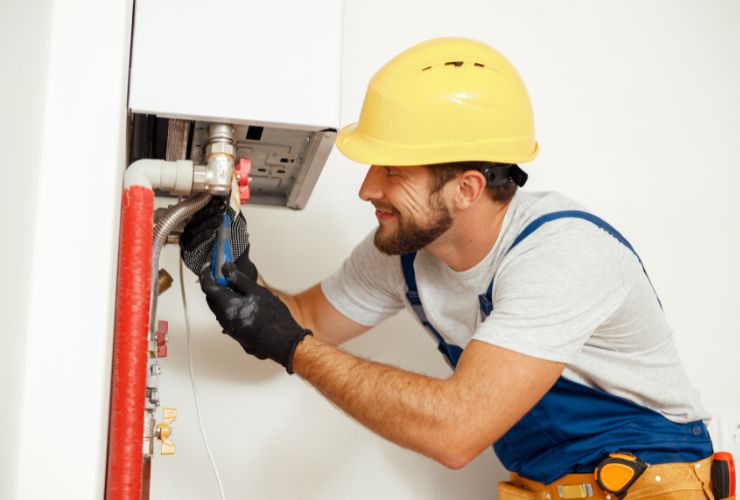man working on tankless electric hot water system