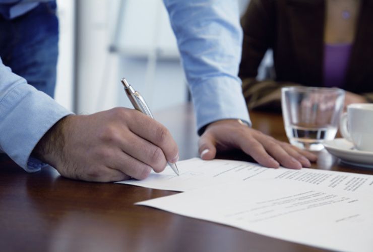 man signing solar quote papers