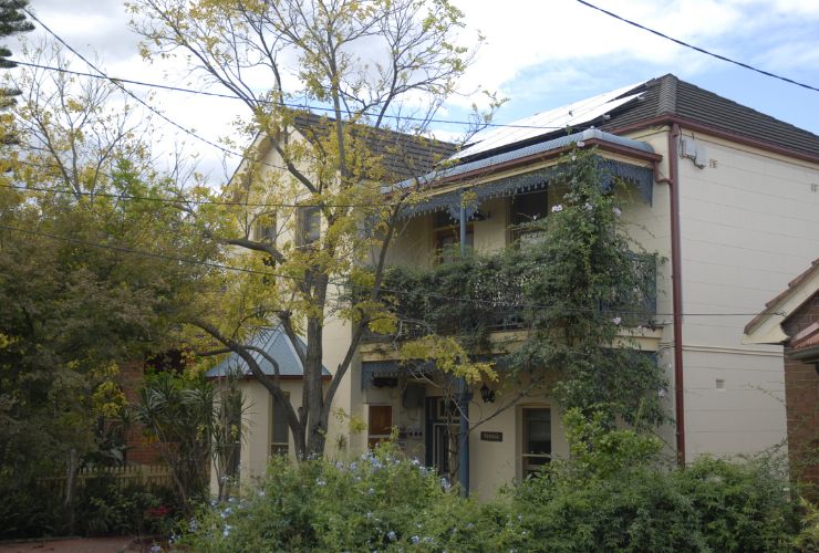 two storey house with trees in front of it 