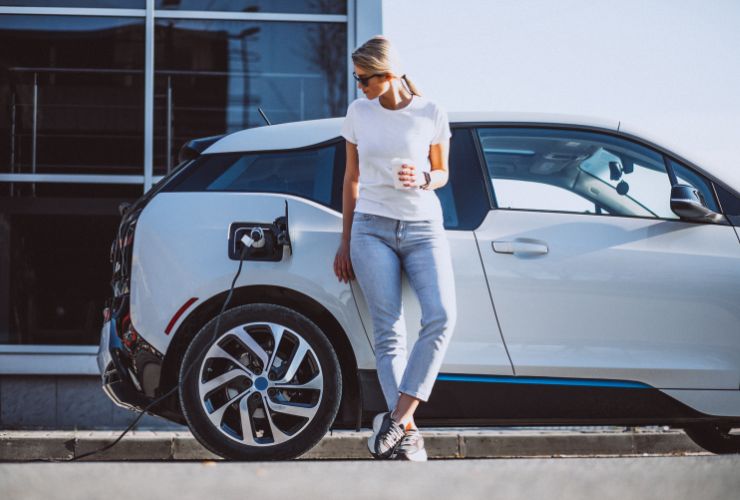 woman standing in front of an EV charger