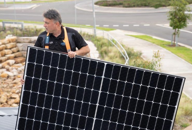 solar installer carrying solar panel