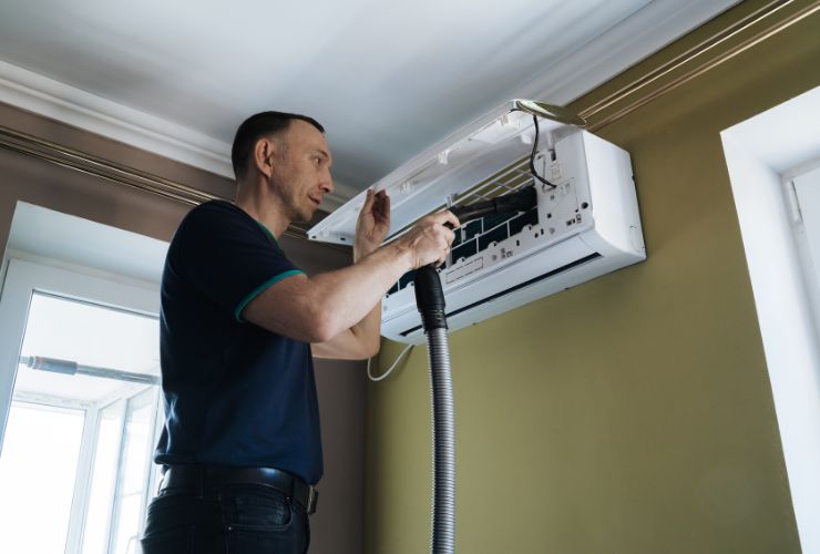 person cleaning air conditioner so there are no health issues