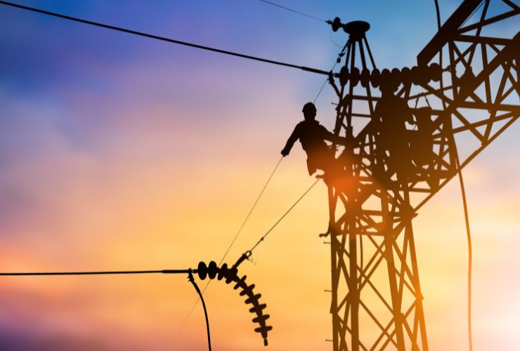 powerlines and worker where electricity is sent back to the grid and a feed-in tariff is paid 