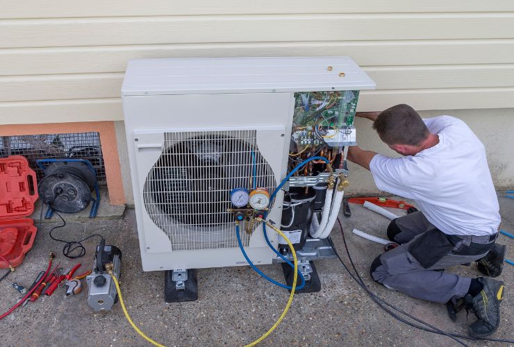 installers working on outdoor air conditioner unit