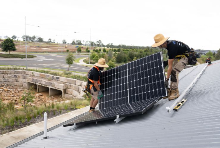 installers carrying panels on roof