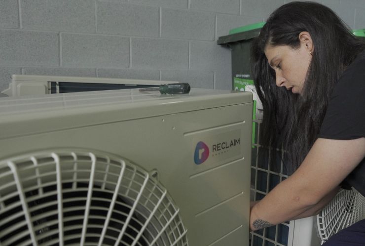 Reclaim heat pump being adjusted by a tradesperson