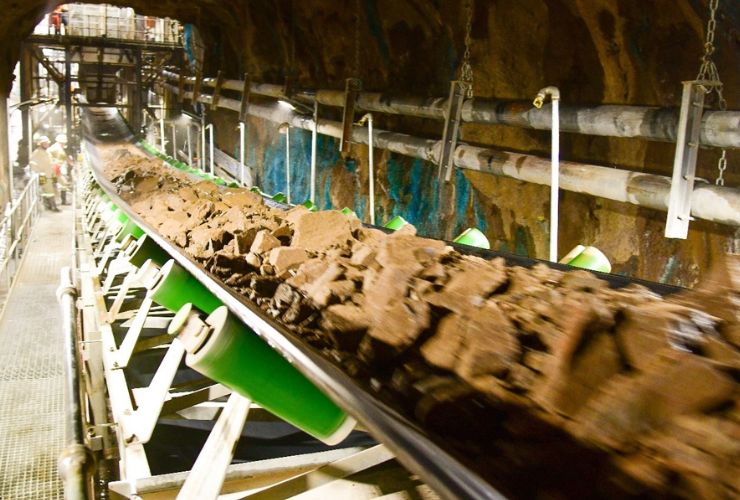 raw copper being taken from a mine on a conveyer belt