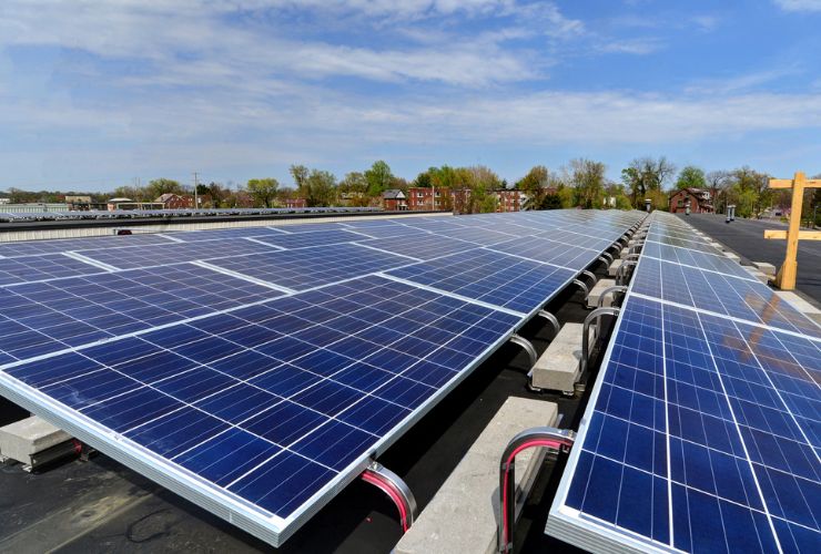 solar panels installed on an angle on top of a flat concrete roof 