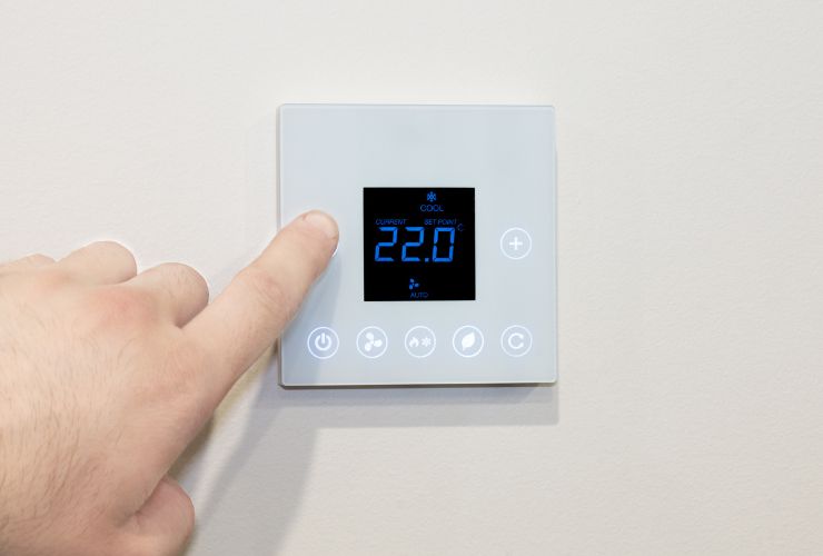 person changing air conditioner temperature