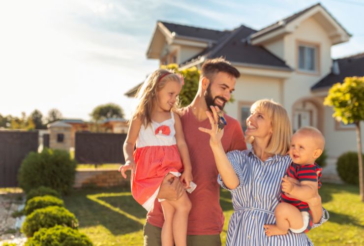 family posing in front of home with an Energy Performance Certificate