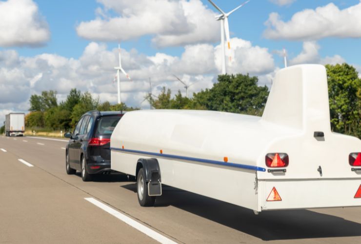 electric vehicle towing a heavy load which is a plane glider 