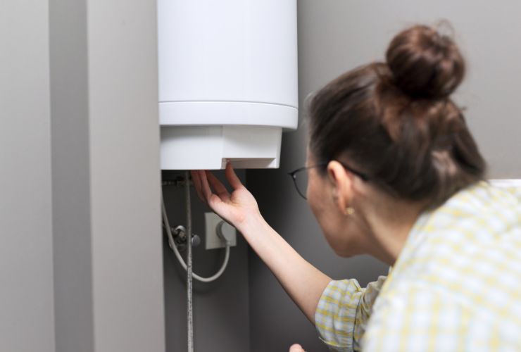 woman inspecting tankless hot water heater