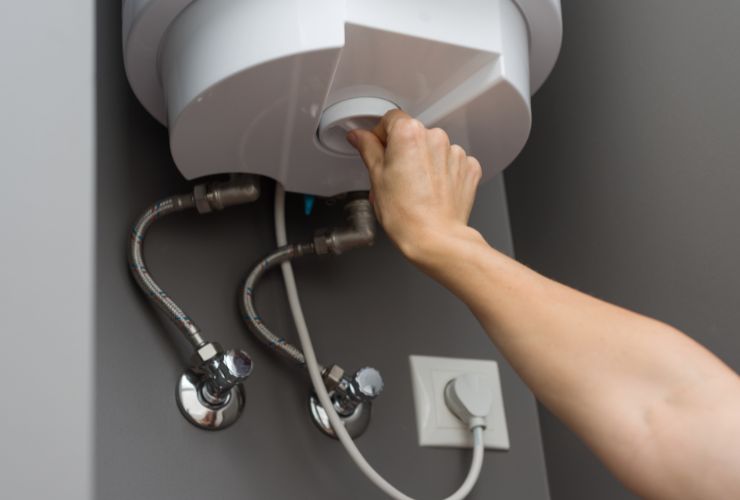 person inspecting tankless hot water heater