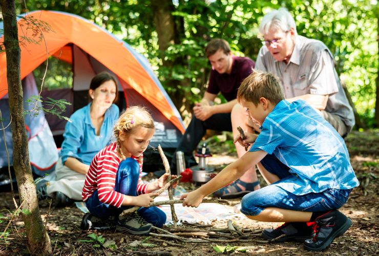 kids playing with sticks while camping with family