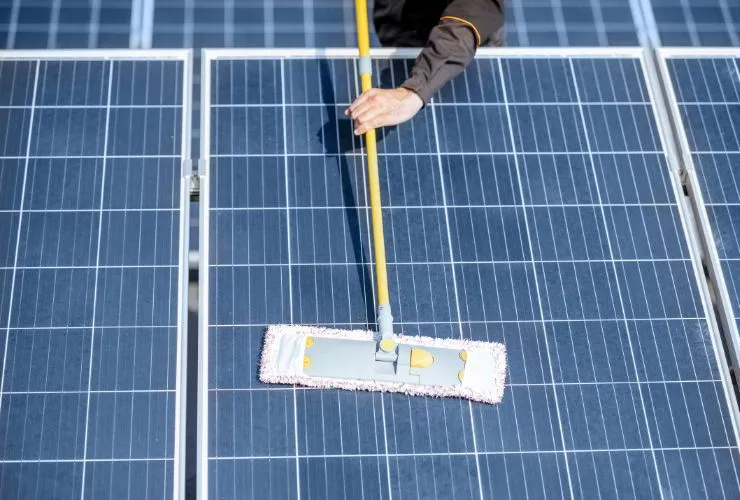 person cleaning solar panel