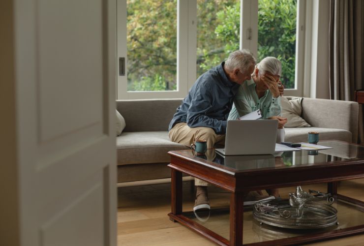 elderly couple looking at solar quote with sadness